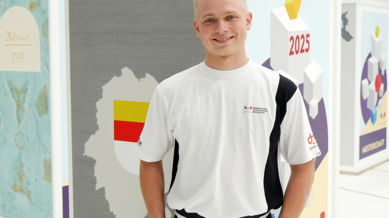 Maler und Lackierer Jonas Schneegans in weiß gekleidet posiert fürs Foto.